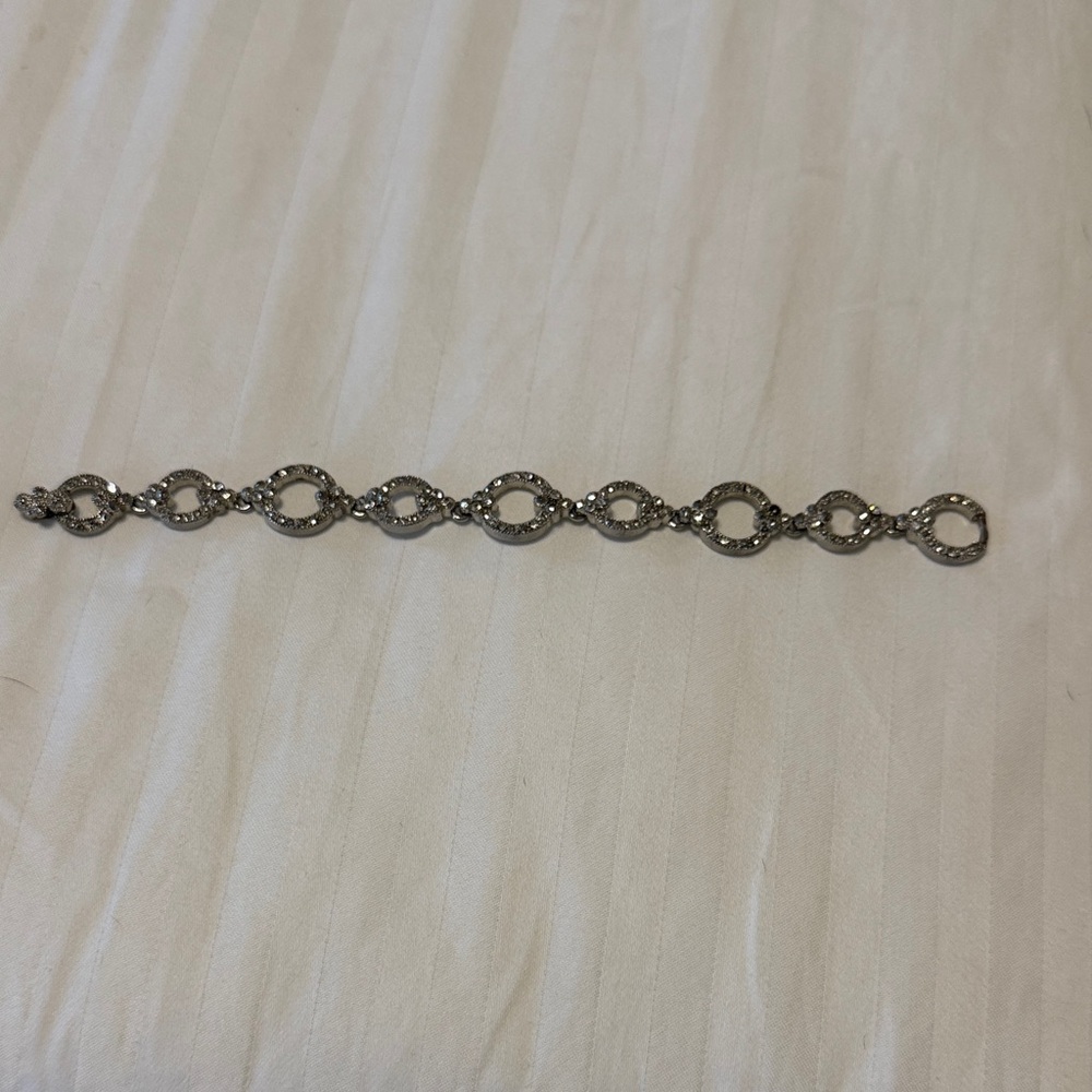 Silver tone crystal bracelet with magnetic closure.